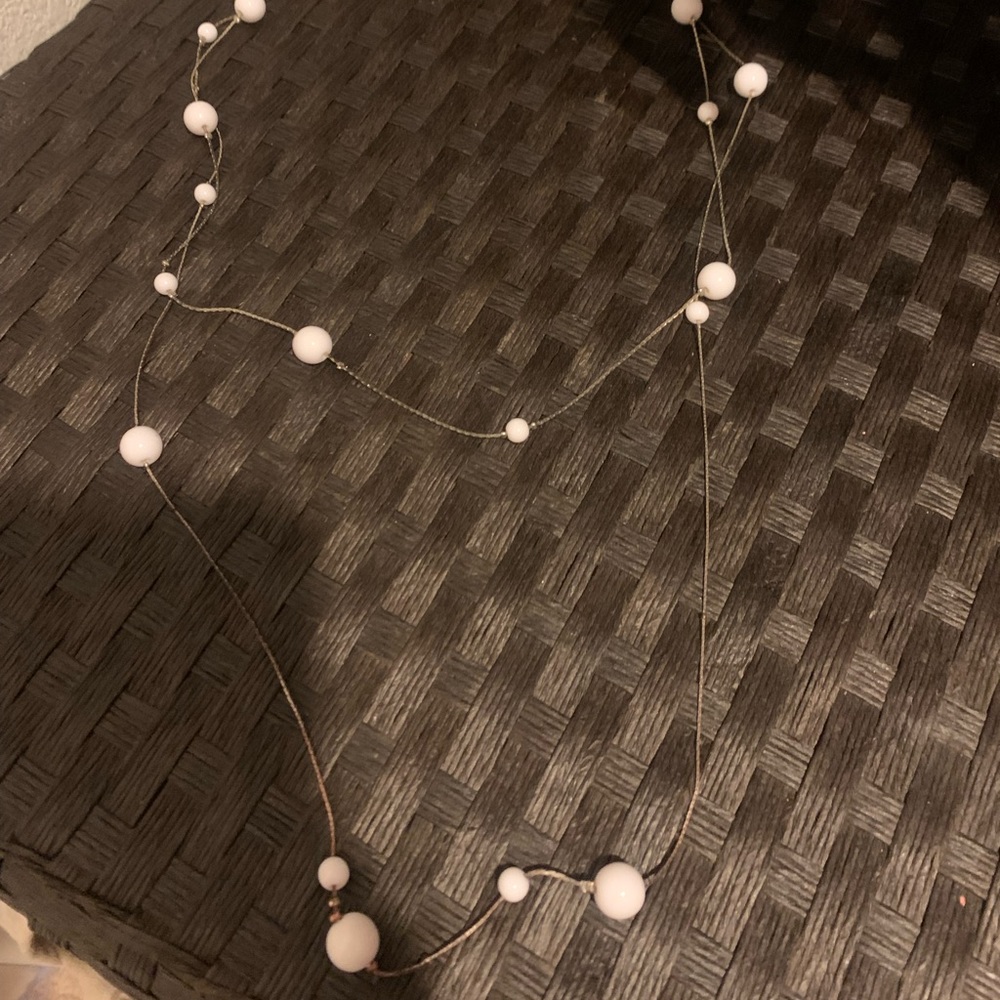 Gold necklace with white pearls on it 🤍
